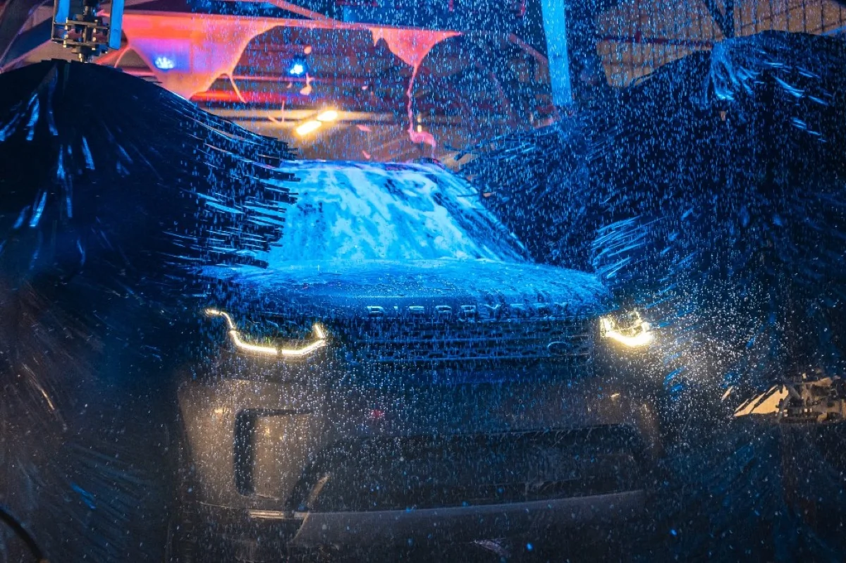 SUV u automatizovanom tunelu Bluewash: pranje pod pritiskom, rotirajuće četke i plavo osvetljenje; brzo tunelsko pranje bez dugih redova